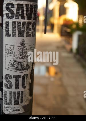 Politischer Ausdruck auf den Straßen von London, Großbritannien - Ein COVID-Denial-Aufkleber auf einem Lampenposten, der Ironie verwendet, um gegen gesellschaftliche Sperren zu protestieren. Stockfoto