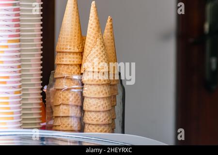 Haufen knusprig brauner Eiswaffelkegel stehen auf dem Laden Stockfoto