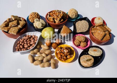 Makar sankranti Festival Traditionen des Servierens und Essens Peanut Chikki, Sesam laddu, til ladoo, indischer grüner Apfel ber, Bora, Erdnüsse. Und Stockfoto