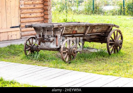 Ein alter Wagen steht in der Nähe eines Holzhauses auf dem Land Stockfoto