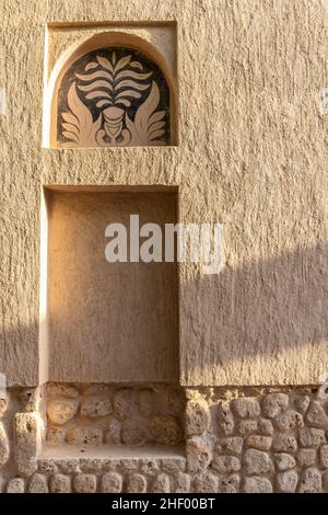 Arabisches Fensterportal in Steinmauer mit Ornamenten, traditionelle arabische Architektur, Al Fahidi, Dubai, Vereinigte Arabische Emirate. Stockfoto