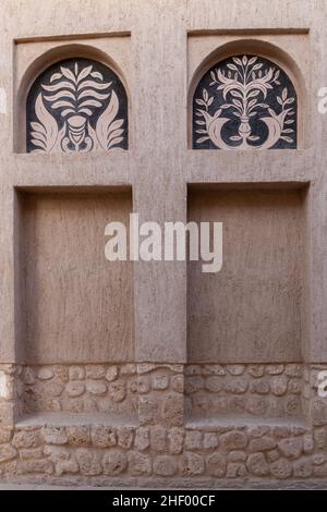 Fensterportale im arabischen Stil in Steinmauer mit Ornamenten, traditionelle arabische Architektur, Al Fahidi, Dubai, Vereinigte Arabische Emirate. Stockfoto