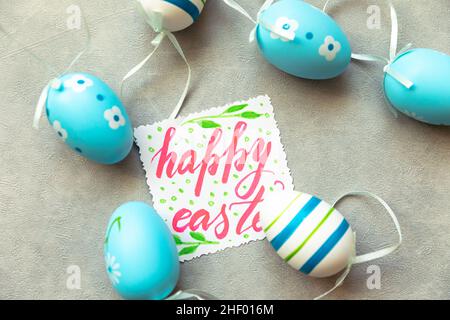 Happy Easter Konzept. Vorbereitung auf den Urlaub. Blaue Ostereier Inschrift FROHE OSTERBRIEFE Text auf betonsteingrauem Hintergrund. Flach, oben liegend, Kopieplatz Stockfoto