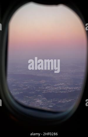 Blick auf den Sonnenuntergang durch ein Flugzeugfenster in Porto, Portugal Stockfoto