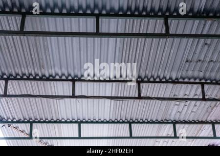 Silbernes Eisendach, das das Sonnenlicht in der Autogarage bedeckt Stockfoto