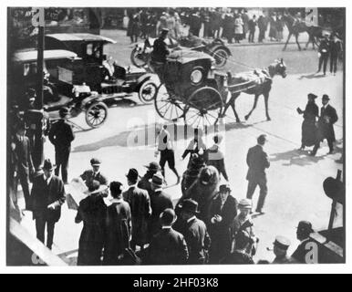 Der Druck zeigt Menschen, Pferdekutsche und Autos auf der Straße in starkem Sonnenlicht. 1916. Strand, Paul, 1890-1976, Fotograf. Stockfoto