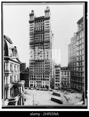 Blick auf das Park Row Building, Manhattan, New York City, im Jahr 1912, zeigt Autos, die auf der Straße geparkt sind und Trolleys. Stockfoto