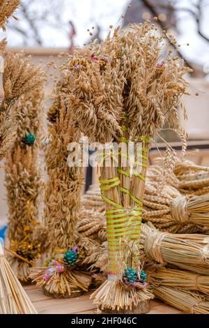 Vertikales Bild von Didukh als traditionelles ukrainisches Weihnachtssymbol auf dem Souvenirmarkt - Weizenschaf, die zur Weihnachtsfeier in der Ukraine verwendet wird. Ein Stockfoto