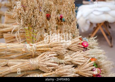 Viele symbolische Garben Weizen mit Blumenschmuck - Didukh als ukrainisches Weihnachtssymbol auf dem Souvenirmarkt - Garbe Weizen für Zelebrati verwendet Stockfoto