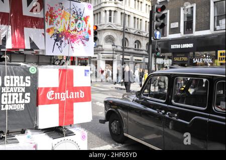 Souvenir-T-Shirts werden am Marktstand und am schwarzen Taxi in der Oxford Street in London ausgestellt. Stockfoto