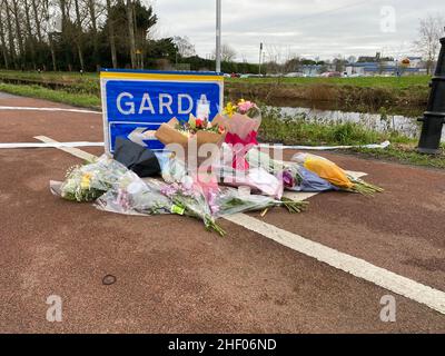 Blumen und Botschaften wurden an einem Garda-Checkpoint in Tullamore hinterlassen, nachdem eine junge Frau, die vor Ort als Ashling Murphy bezeichnet wurde, am Mittwochabend getötet wurde. Sie starb nach einem Angriff, während sie am Mittwoch um 4pm Uhr am Kanalufer in Capphängen joggte. Ausgabedatum: Donnerstag, 13. Januar 2022. Stockfoto