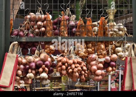 Zwiebeln und Knoblauch hängen am Marktstand, Borough Market in Southwark London, Großbritannien. Stockfoto