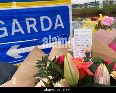 Eine Nachricht über Blumen, die an einem Garda-Checkpoint in Tullamore hinterlassen wurden, nachdem eine junge Frau, die vor Ort als Ashling Murphy bezeichnet wurde, am Mittwochabend getötet wurde. Sie starb nach einem Angriff, während sie am Mittwoch um 4pm Uhr am Kanalufer in Capphängen joggte. Ausgabedatum: Donnerstag, 13. Januar 2022. Stockfoto