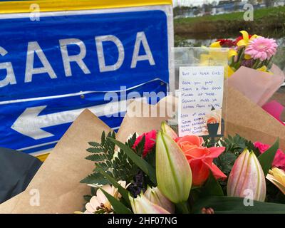 Eine Nachricht über Blumen, die an einem Garda-Checkpoint in Tullamore hinterlassen wurden, nachdem eine junge Frau, die vor Ort als Ashling Murphy bezeichnet wurde, am Mittwochabend getötet wurde. Sie starb nach einem Angriff, während sie am Mittwoch um 4pm Uhr am Kanalufer in Capphängen joggte. Ausgabedatum: Donnerstag, 13. Januar 2022. Stockfoto