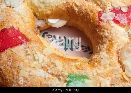 Dekorierte Tischdecke mit einem Stechpalme am Weihnachtstag in der Mitte eines großen Donut-Kuchen mit Schlagsahne gefüllt und mit rot und gr Stockfoto