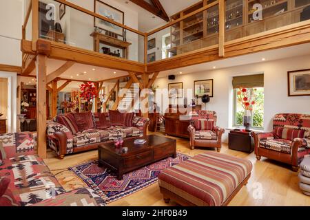 Abbotsley, Cambridgeshire - 24. Juli 2018: Wohnzimmer und Lounge mit hoher Decke und galleried Landung im Haus Scheune Umbau voll furni Stockfoto