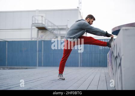 Junger Mann, der sich vor einem Lauf aufwärmt Stockfoto
