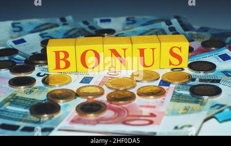 Euro auf einem Tisch mit gelben Steinen und dem Text "Bonus" Konzept des Bonusgeldes. Stockfoto