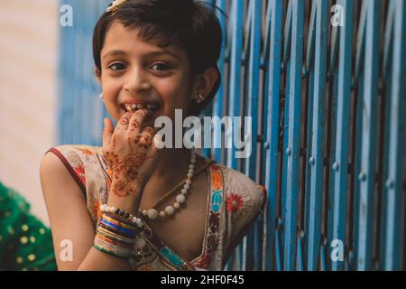 Peshawar, Pakistan - 08. Juni 2020: Lächelndes pakistanisches Mädchen mit dunklen Haaren und buntem Kleid Stockfoto