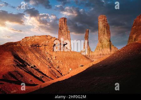 Die Three Sisters stehen hoch über der Landschaft im Monument Valley Tribal Park im Norden Arizonas. Stockfoto