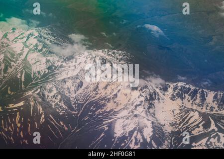 Luftaufnahme vom Flugzeugfenster aus, Vereinigte Arabische Emirate, mit Blick auf die hellen und bunten Wolken unter der Stadt Dubai Stockfoto