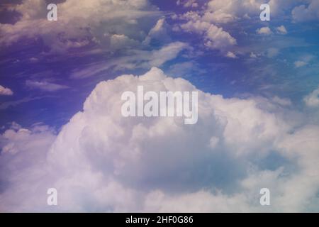 Luftaufnahme vom Flugzeugfenster aus, Vereinigte Arabische Emirate, mit Blick auf die hellen und bunten Wolken unter der Stadt Dubai Stockfoto