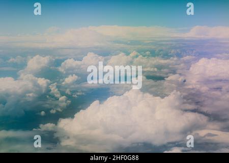 Luftaufnahme vom Flugzeugfenster aus, Vereinigte Arabische Emirate, mit Blick auf die hellen und bunten Wolken unter der Stadt Dubai Stockfoto
