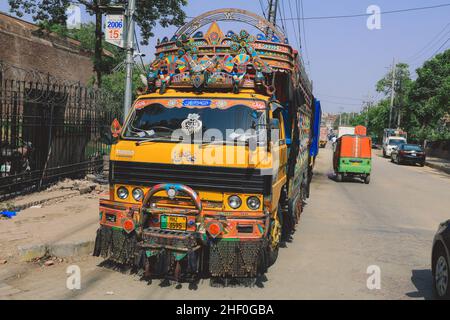 Lahore, Pakistan - 1. Juli 2020: Heller und farbenfroher gelber pakistanischer LKW mit traditioneller Dekoration und Design auf der Lahore Street Stockfoto