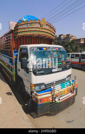 Lahore, Pakistan - 1. Juli 2020: Heller und farbenfroher gelber pakistanischer LKW mit traditioneller Dekoration und Design auf der Lahore Street Stockfoto