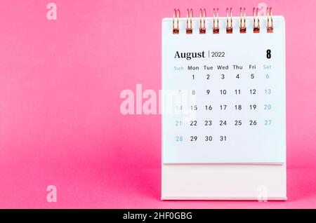 Der Tischkalender für August 2022 auf rosa Hintergrund. Stockfoto