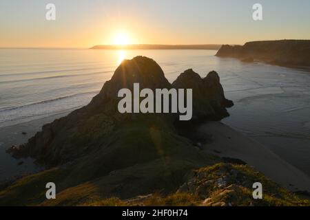 Three Cliffs Bay mit Sonnenuntergang hinter Oxwich Point in Südwales Stockfoto