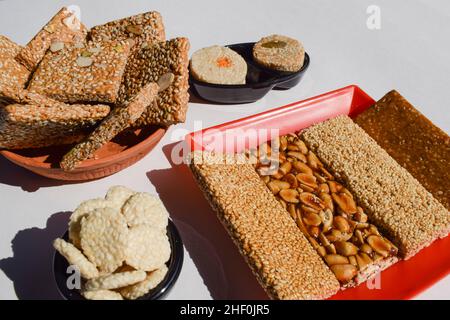 Leckere Peanut Chikki, Sesamsamen Chiki, Rajgira oder Amaranth Chikky und zerkleinerte Peanut Chikkis. Sankranti spezielle traditionelle Süßigkeiten verschiedene Töpfe Stockfoto