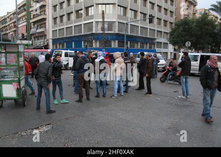 (220113) -- TRIPOLIS, 13. Januar 2022 (Xinhua) -- Busfahrer versammeln sich während einer Protestveranstaltung in Tripolis, Libanon, am 13. Januar 2022 auf einer Straße. Die Libanesen veranstalteten am Donnerstag einen landesweiten Protest gegen steigende Preise und sich verschlechternde Lebensbedingungen, die durch die langfristige Wirtschaftskrise verursacht wurden. Fahrer und Bürger gingen auf die Straßen der Hauptstadt Beirut, Tripolis, Khalde und anderer Städte, parkt ihre Autos mitten auf den Straßen und verbrennt Staubkörbe, um die Hauptstraßen zu blockieren. (Foto von Khaled Habashiti/Xinhua) Stockfoto