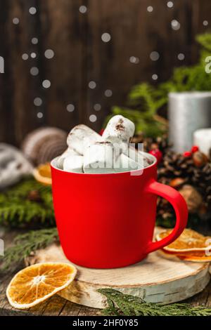 Heißer Kakao oder Schokolade mit Salmmidschoten. Weihnachtliche traditionelle Einrichtung, festliche Neujahrsgestaltung. Das Konzept der Gemütlichkeit, Holzhintergrund Stockfoto