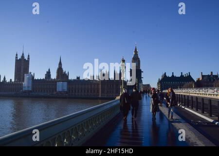 London, Großbritannien 13th. Januar 2022. An einem klaren, sonnigen Tag laufen die Menschen an den Houses of Parliament auf der Westminster Bridge vorbei. Kredit: Vuk Valcic / Alamy Live Nachrichten Stockfoto