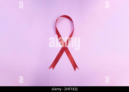 Rotes Band auf rosa Hintergrund nationaler HIV-Testtag, Welt-Aids-Tag. Sensibilisierungskampagne Stockfoto