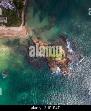 Landschaftlich schöner Blick auf den Papageienfelsen - kleine Insel am Mirissa Beach in Sri Lanka. Bremswellen Draufsicht Luftaufnahme von fliegender Drohne. Reisen und e Stockfoto