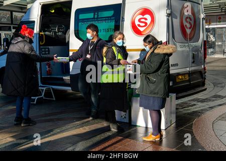 Slough, berkshire, Großbritannien. 13th. Januar 2022. NHS Test and Trace und Solutions4Health waren heute im Stadtzentrum von Slough und gaben kostenlose Covid-19 Lateral Flow Self Testing Kits in Kartons mit 20 Tests heraus. Die Rapid Covid-19 (Antigen) Selbsttestpakete des Orient Gene waren auf ein Pack pro Person beschränkt. Es wurde heute bekannt gegeben, dass die Selbstisolationszeit von Covid-19 von 7 Tagen auf 5 Tage für die Menschen, die vollständig abgekoppert sind, verkürzt werden soll. Quelle: Maureen McLean/Alamy Live News Stockfoto