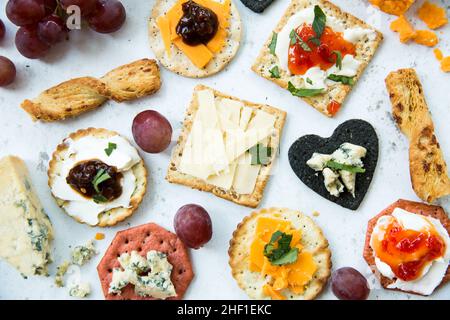 Ein flaches Lay-Food-Hintergrund mit einer Auswahl an Käse und Crackern als Aperitif oder Snack mit Garnierung Stockfoto