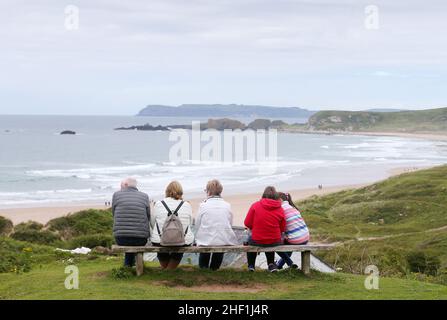 Die Menschen genießen die warme Sonne im Sommer am Strand von Whitepark Bay, Co. Antrim, Nordirland. Stockfoto