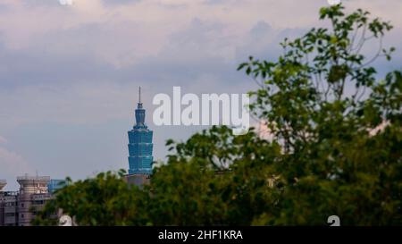 Luftaufnahme des Wahrzeichen-Gebäudes Taipei 101 und des Parks in der modernen Stadt. Hoch aufragender gläserner Wolkenkratzer und Baumwald. Hohes Gebäude, Stadtbild Stockfoto