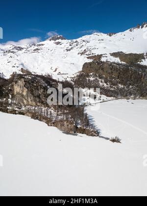 Luftaufnahme einer Inselspitze auf einem gefrorenen See mit Schnee, der die gefrorene Seenoberfläche bedeckt, und Loipen zum Skilanglauf und Wandern. Stockfoto