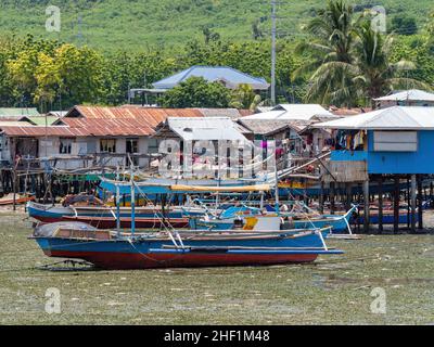 Kleine Thunfisch-Fischerboote bei Ebbe im Dorf Tinoto, Maasim in der Provinz Sarangani im Süden von Mindanao, Philippinen. Stockfoto