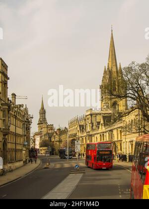 Eine Straßenszene in Oxford, England, mit den legendären britischen Bussen in einer von Türmen und Türmen gesäumten Straße Stockfoto