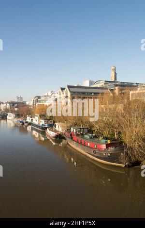 Hausboote auf der Themse mit der neuen Wohnanlage Kew Bridge Road im Vordergrund und der Wohnanlage Brentford Towers im Hintergrund Stockfoto