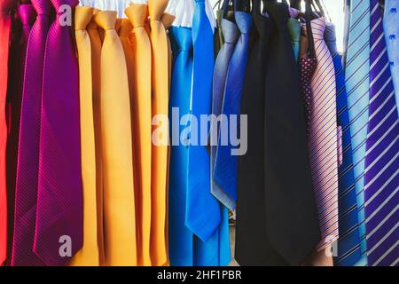 Große Auswahl an bunten Krawatten hängen in den Verkauf auf dem Straßenmarkt. Viele verschiedene Muster bunte Krawatten hängen auf Kleiderständer. Farbe Stockfoto