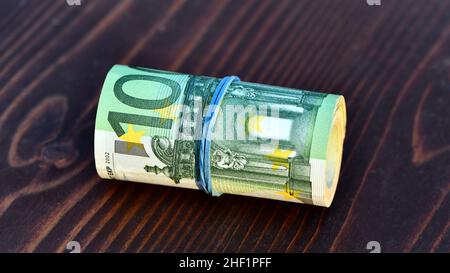 Rolle von 5000 Euro in 100-Euro-Banknoten isoliert auf Holzhintergrund Stockfoto