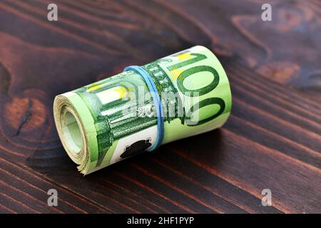 Rolle von 5000 Euro in 100-Euro-Banknoten isoliert auf Holzhintergrund Stockfoto
