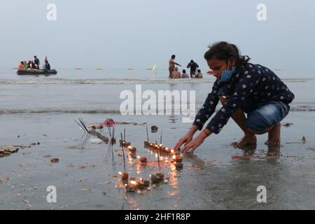 Kalkutta, Indien. 13th Januar 2022. Ein Pilger führt ein Ritual am Strand während des hinduistischen religiösen Festivals von Gangasagar Mela auf der Insel Sagar, etwa 150 km südlich von Kalkutta, Westbengalen, durch. (Foto von Dipa Chakraborty/Pacific Press) Quelle: Pacific Press Media Production Corp./Alamy Live News Stockfoto