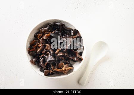 Salat aus eingelegten schwarzen Maultier-Pilzen auf weißem Hintergrund. Blick von oben. Chinesische Küche. Stockfoto